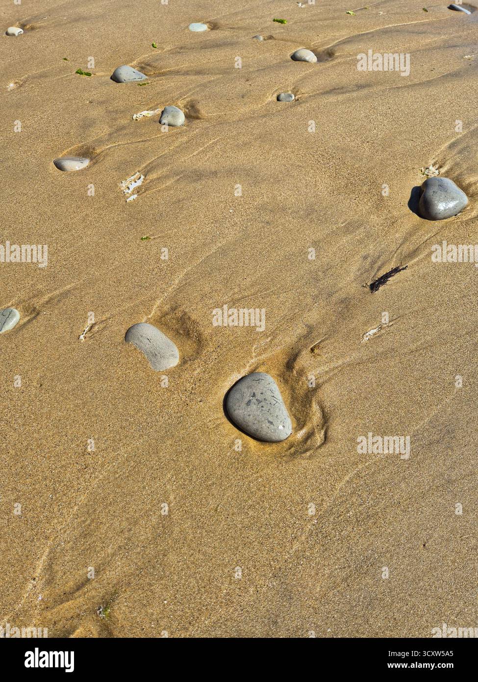 patterns created by the sea. footprints in the sand. sandy beach after high tide. pebbles on wet sand - Smartphone Captured Stock Image