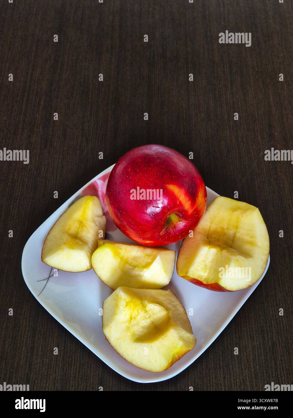 A composition of whole and sliced ​​apples lying on a plate is ready to eat as a healthy and vitamin-rich snack. - Smartphone Captured Stock Image
