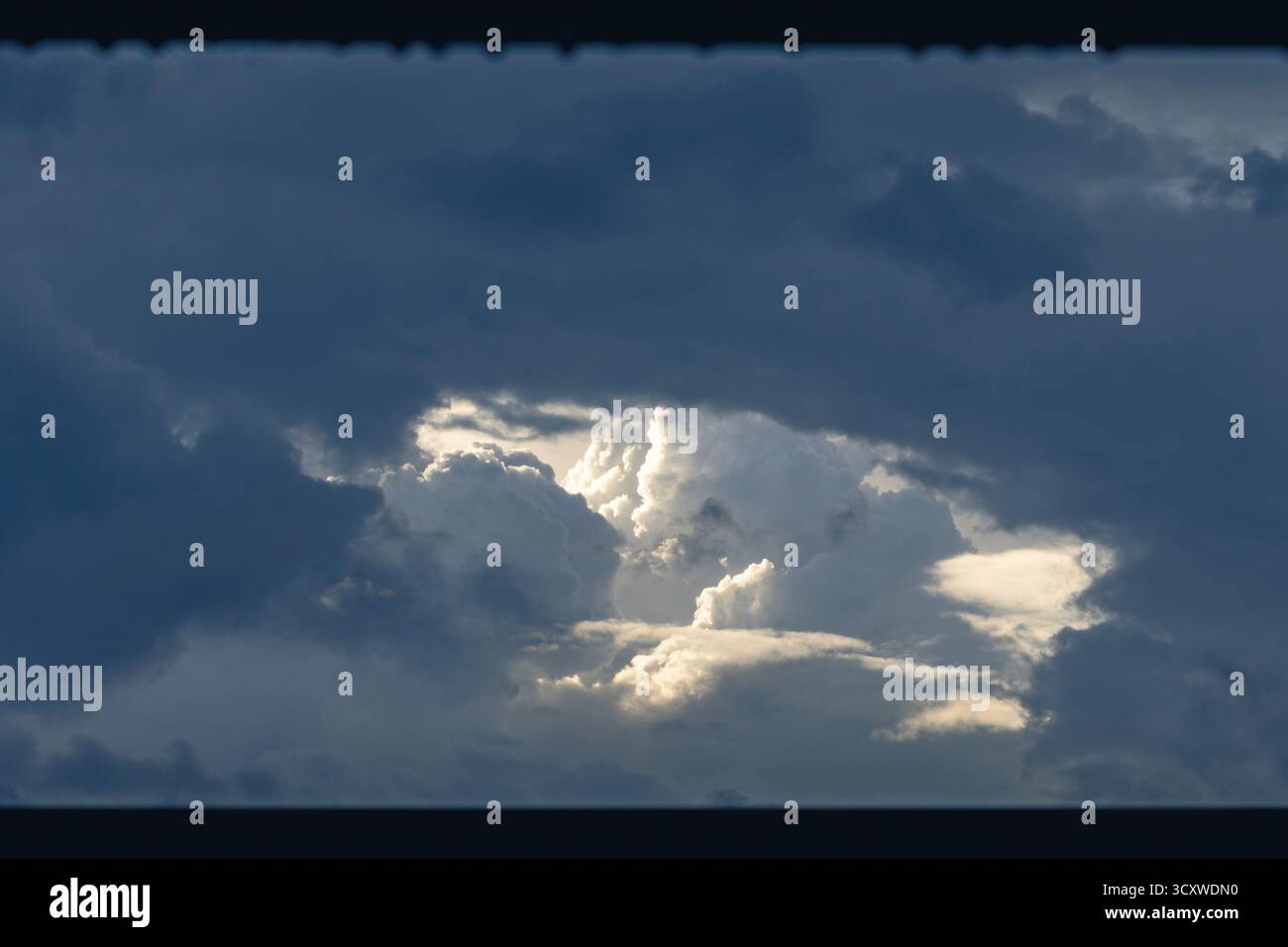 Dramatic storm clouds with sunlight breaking through Stock Photo