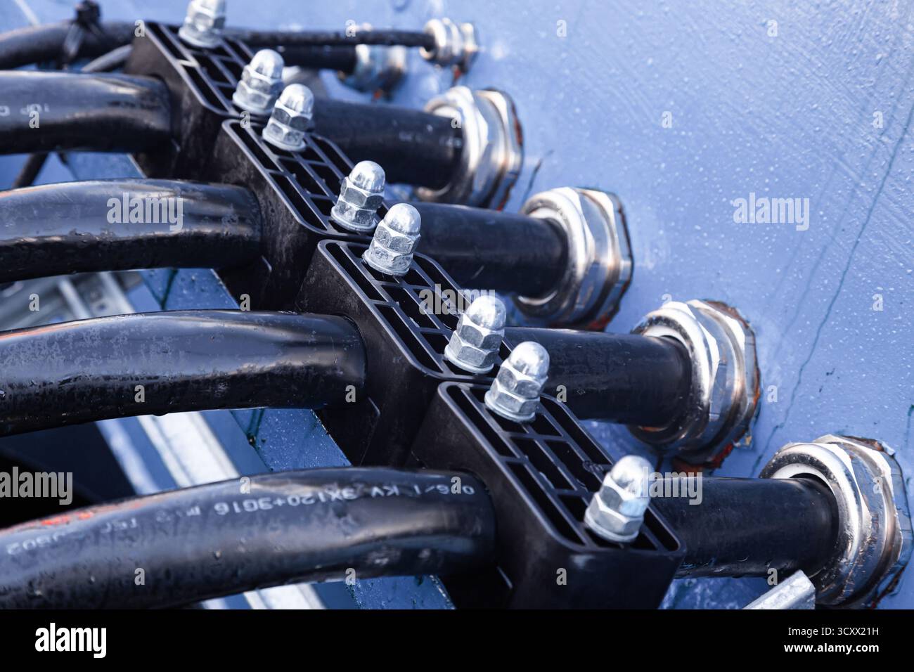 Several powerful electrical cables connected to a junction box Stock Photo