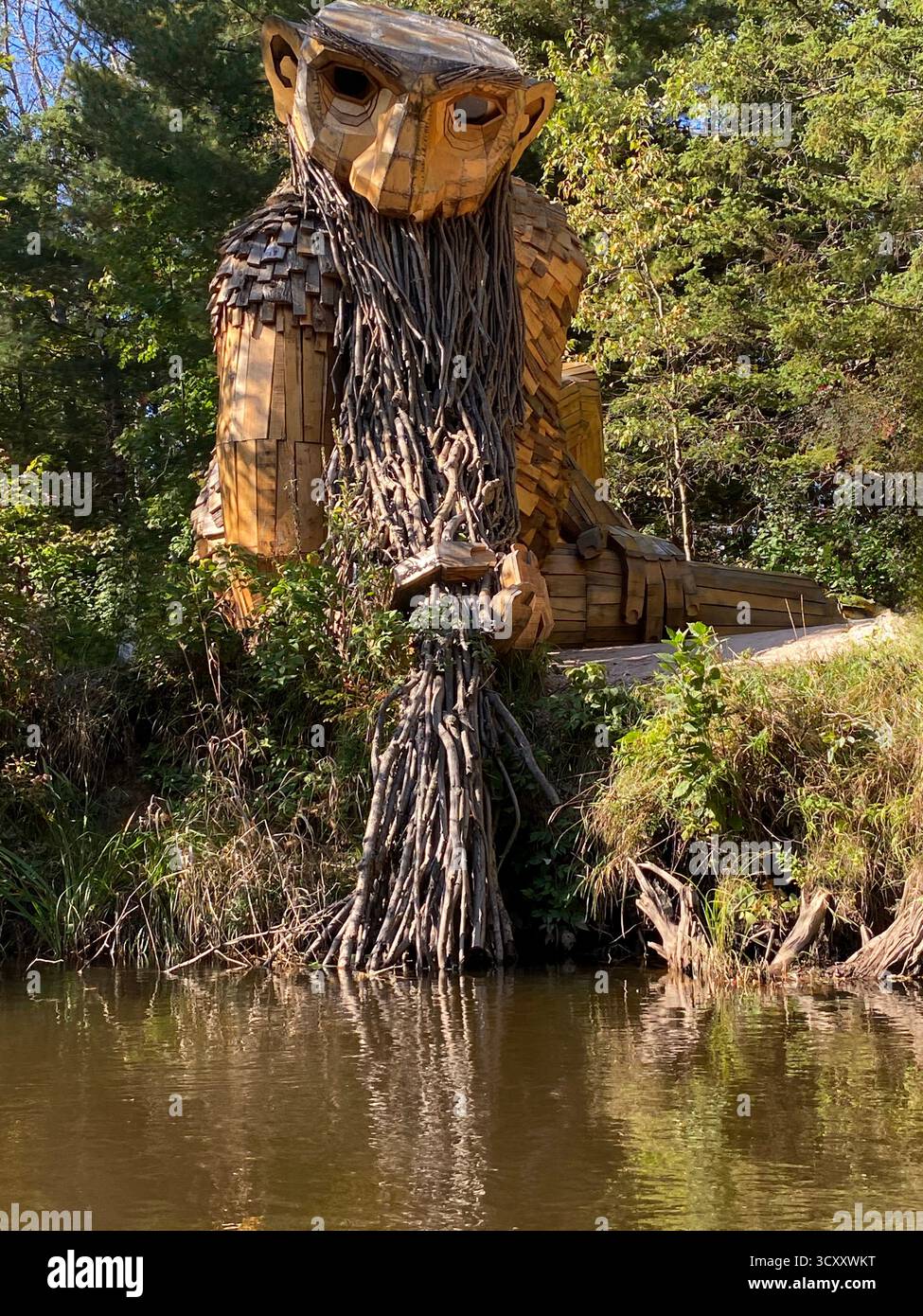 Benny the Beard Fisher, a large troll sculpture, created by Thomas Dambo, along the shore of the Manistique River in Germfask, Michigan, USA - Smartphone Captured Stock Image
