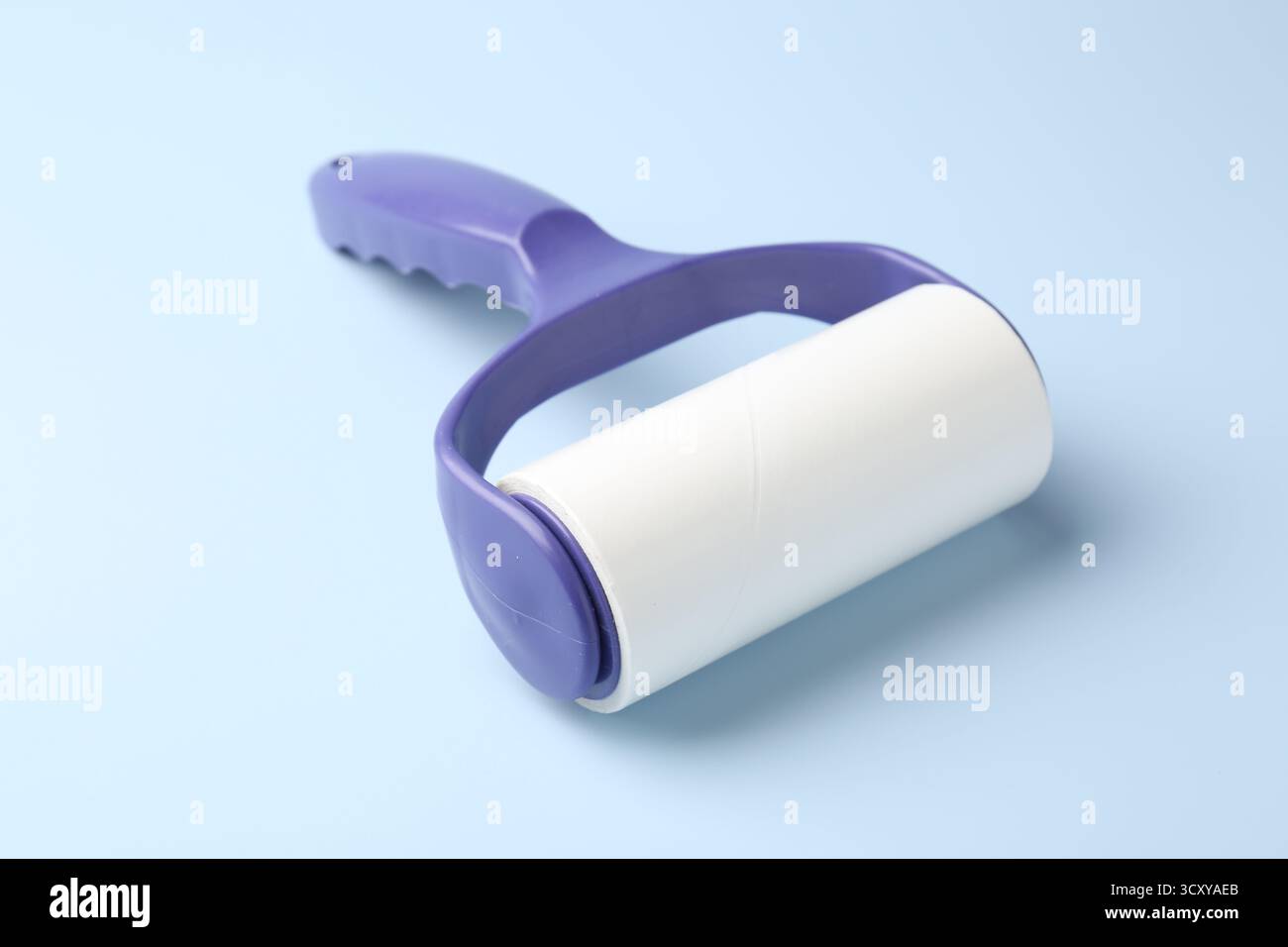 One lint roller on light blue background, closeup Stock Photo