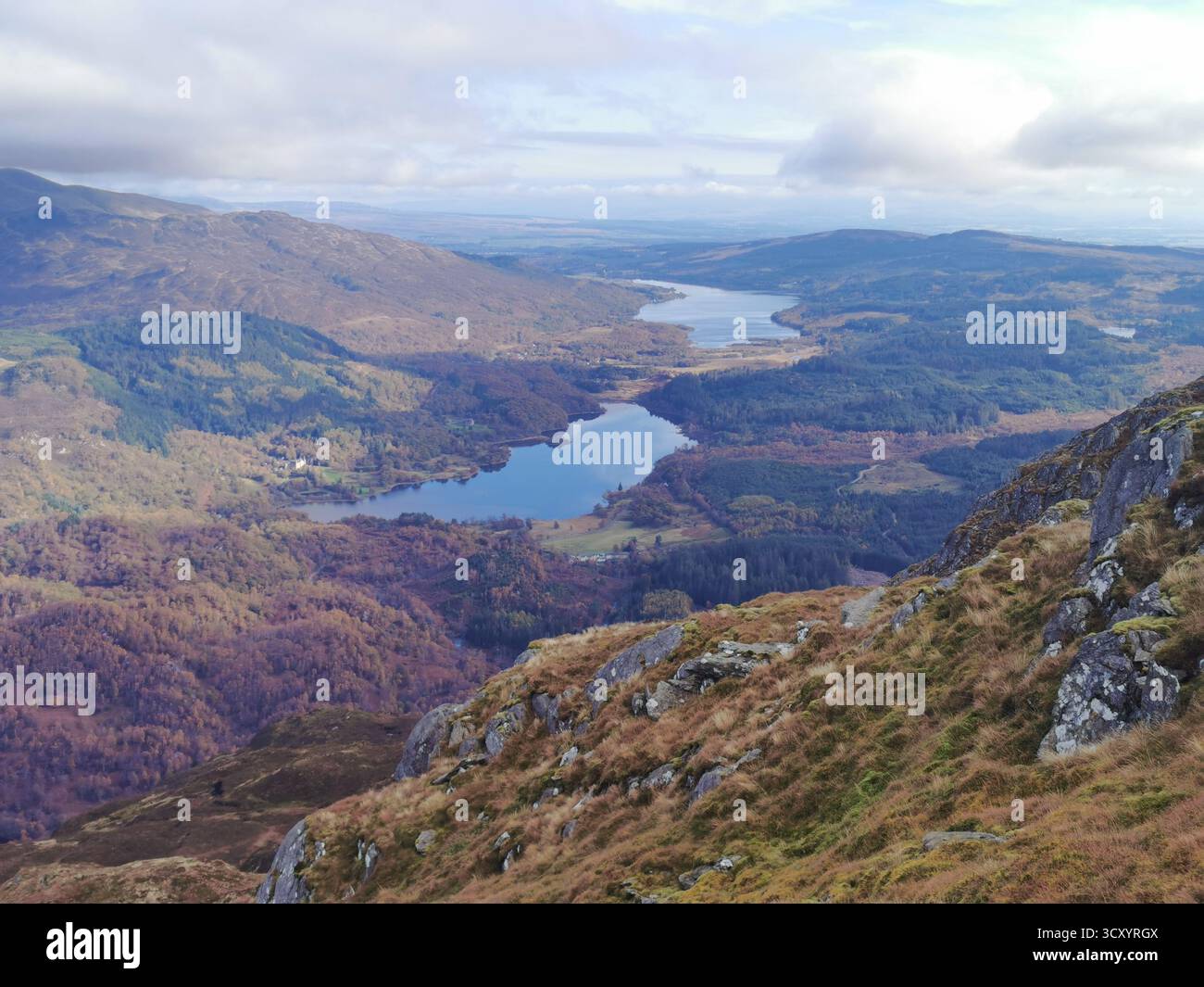 Autumn panorama from Ben Venue summit towards Callander with Loch Achray & Loch Venechar in Scotland’s Trossachs National Park – Highland lakes. - Smartphone Captured Stock Image