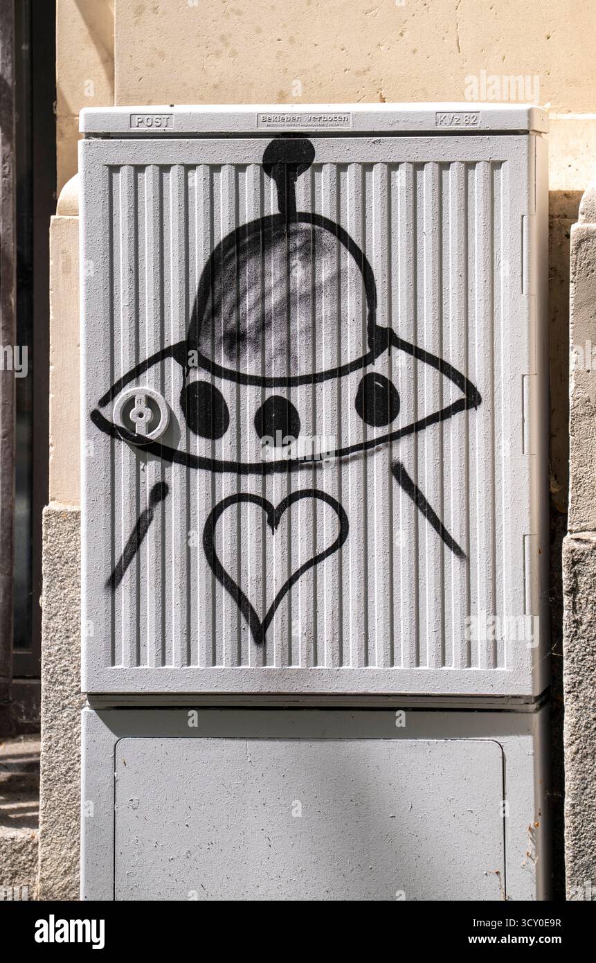 Graffiti on a post switch box, alien spaceship and heart, Stock Photo