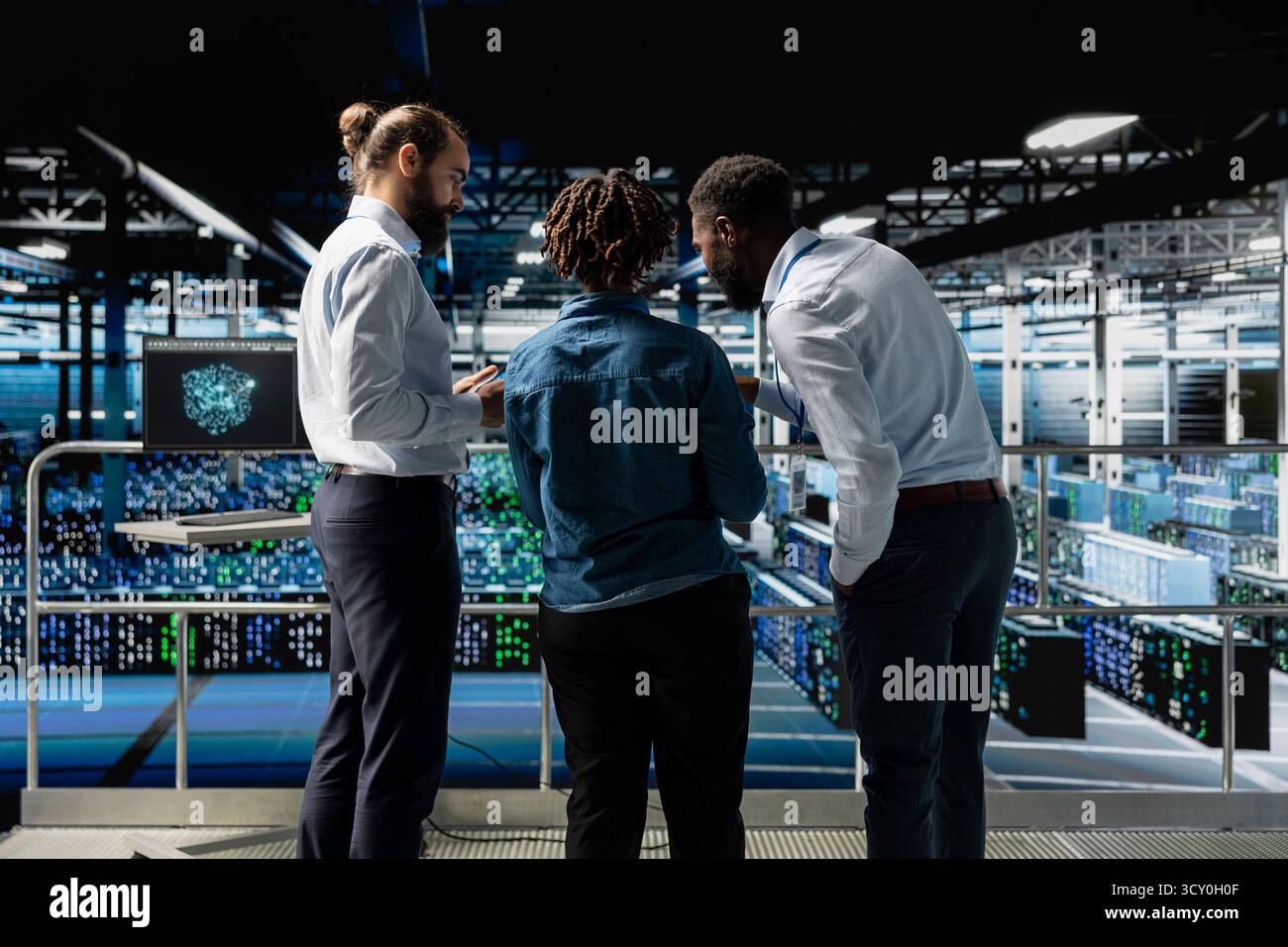 Data center system administrators using laptop to review AI LLM visualization. African american team of engineers use devices to analyze neural network outputs, ensuring stable operations. Stock Photo