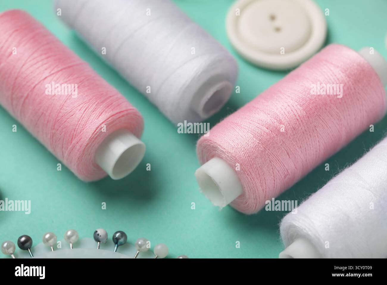 Composition with thread spools on mint background, closeup Stock Photo