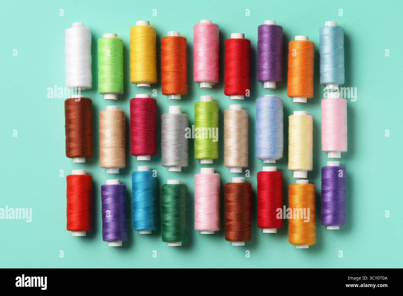 Set of different thread spools on mint background Stock Photo
