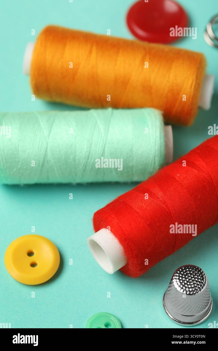 Composition with thread spools on mint background, closeup Stock Photo