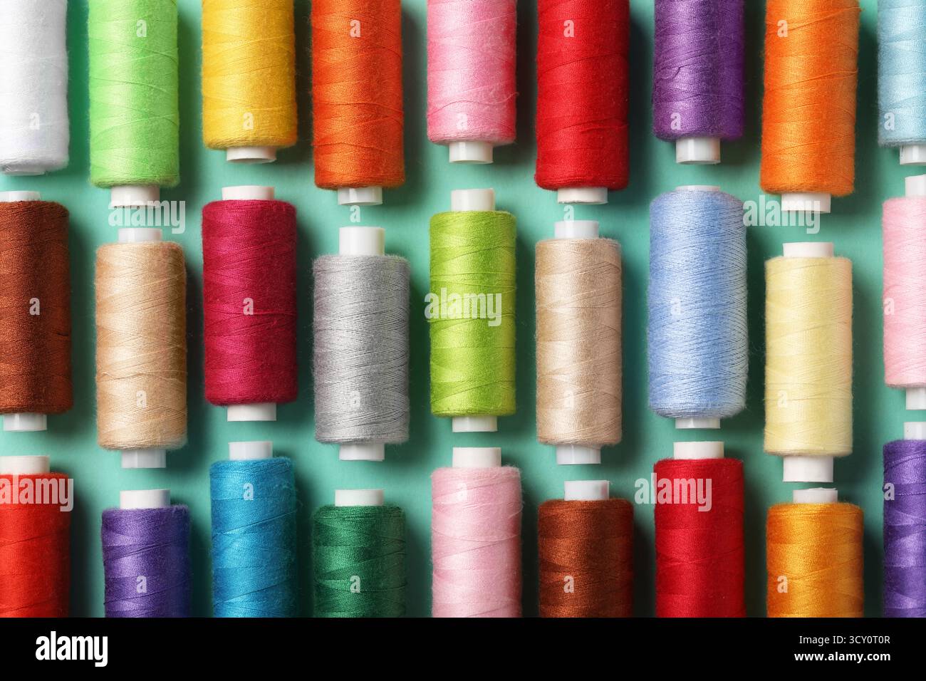 Set of different thread spools on mint background, closeup Stock Photo