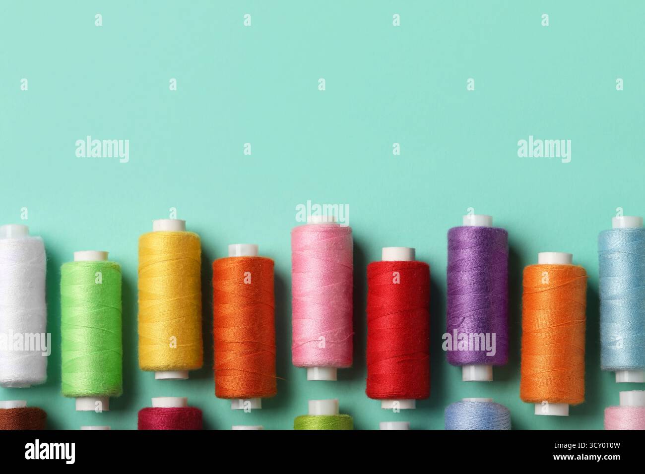 Set of different thread spools on mint background, closeup Stock Photo