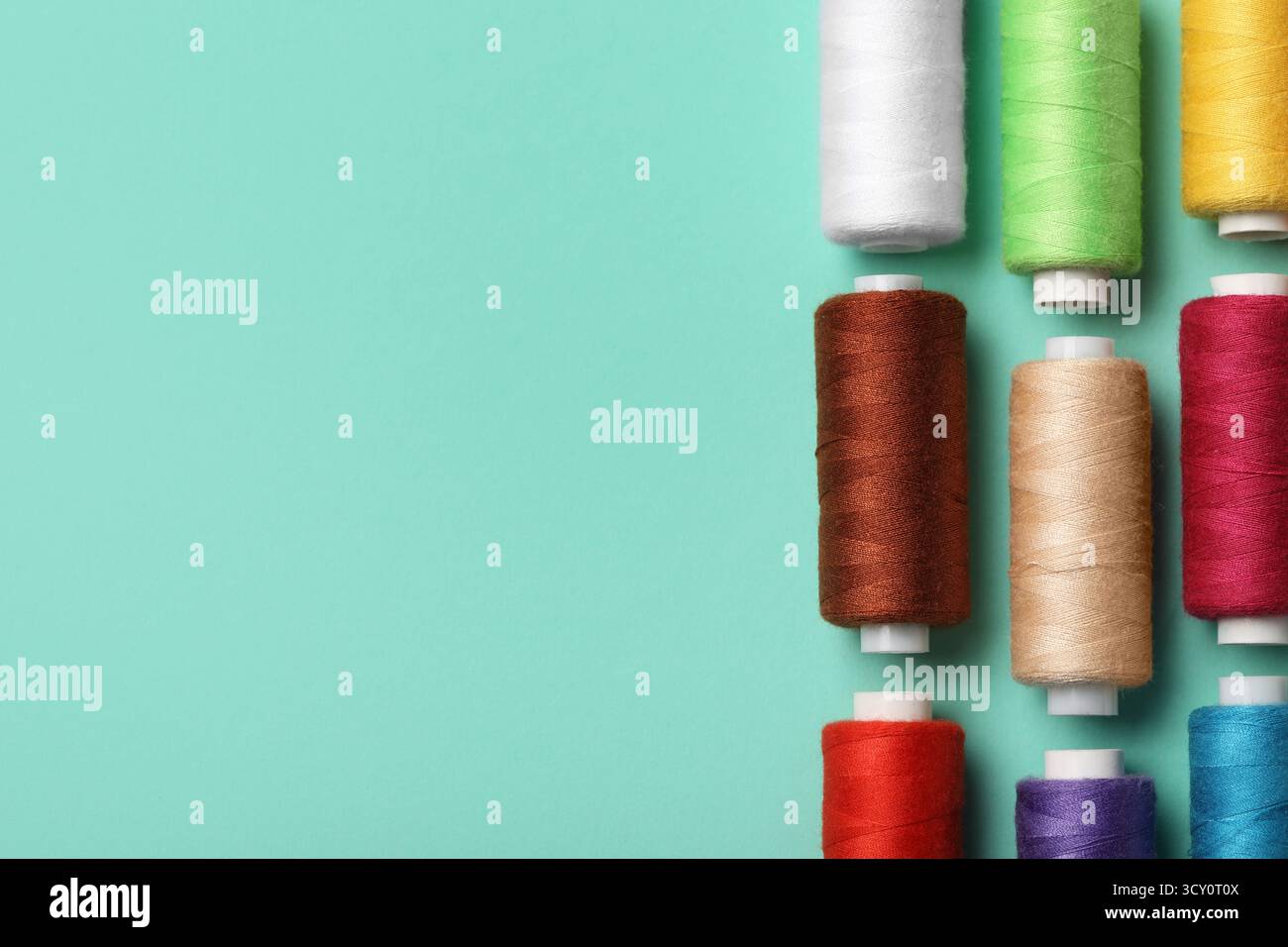 Set of different thread spools on mint background, closeup Stock Photo
