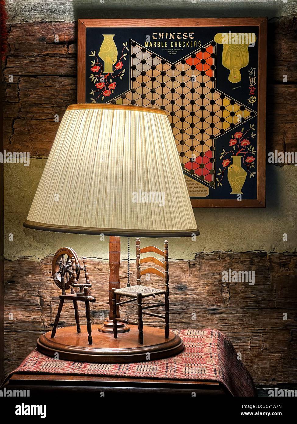 Vintage table lamp with miniature chairs and Chinese marble checkers gameboard on a rustic wooden background - Smartphone Captured Stock Image