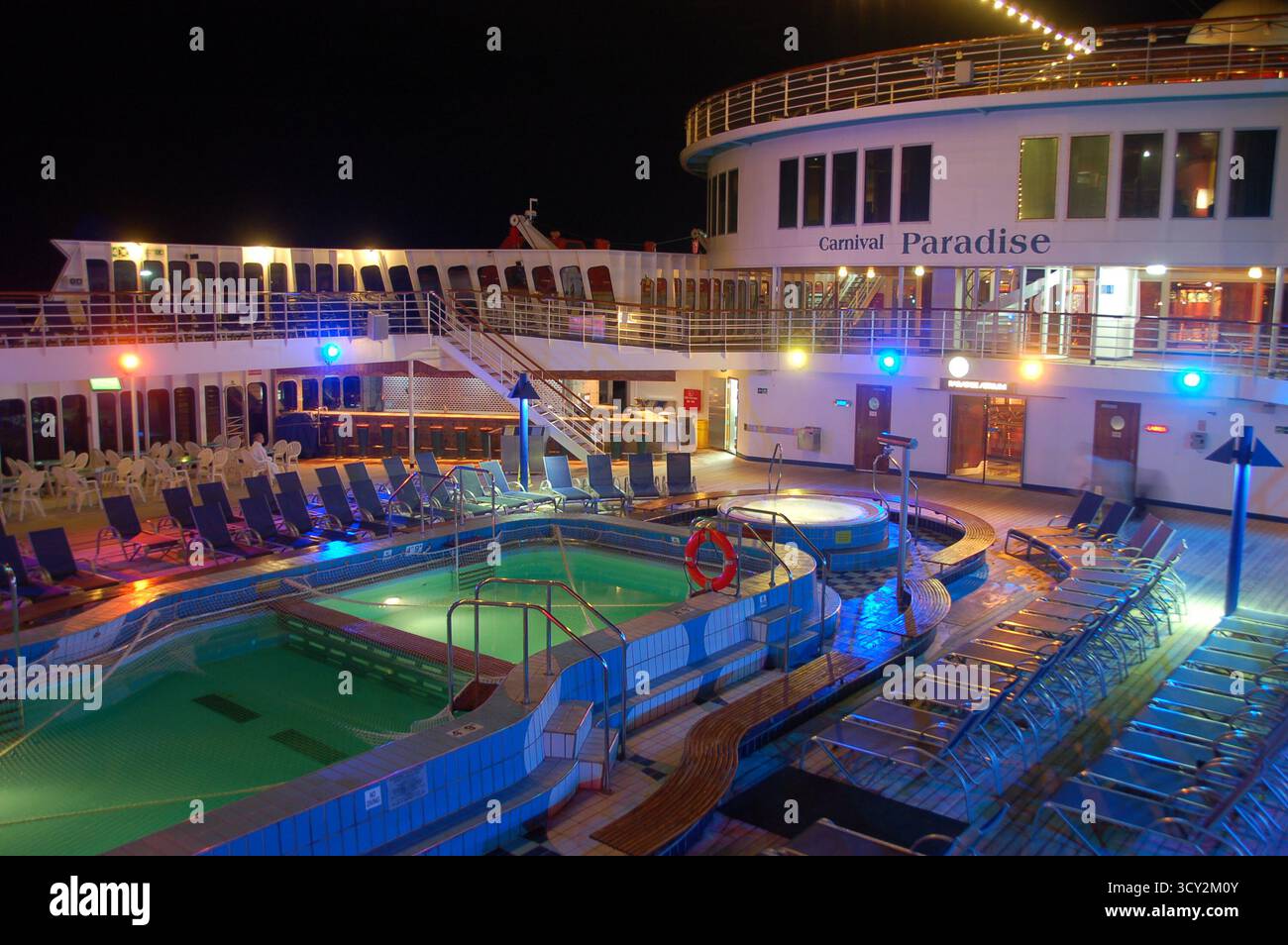 Night view of the Carnival Paradise cruise ship pool deck illuminated