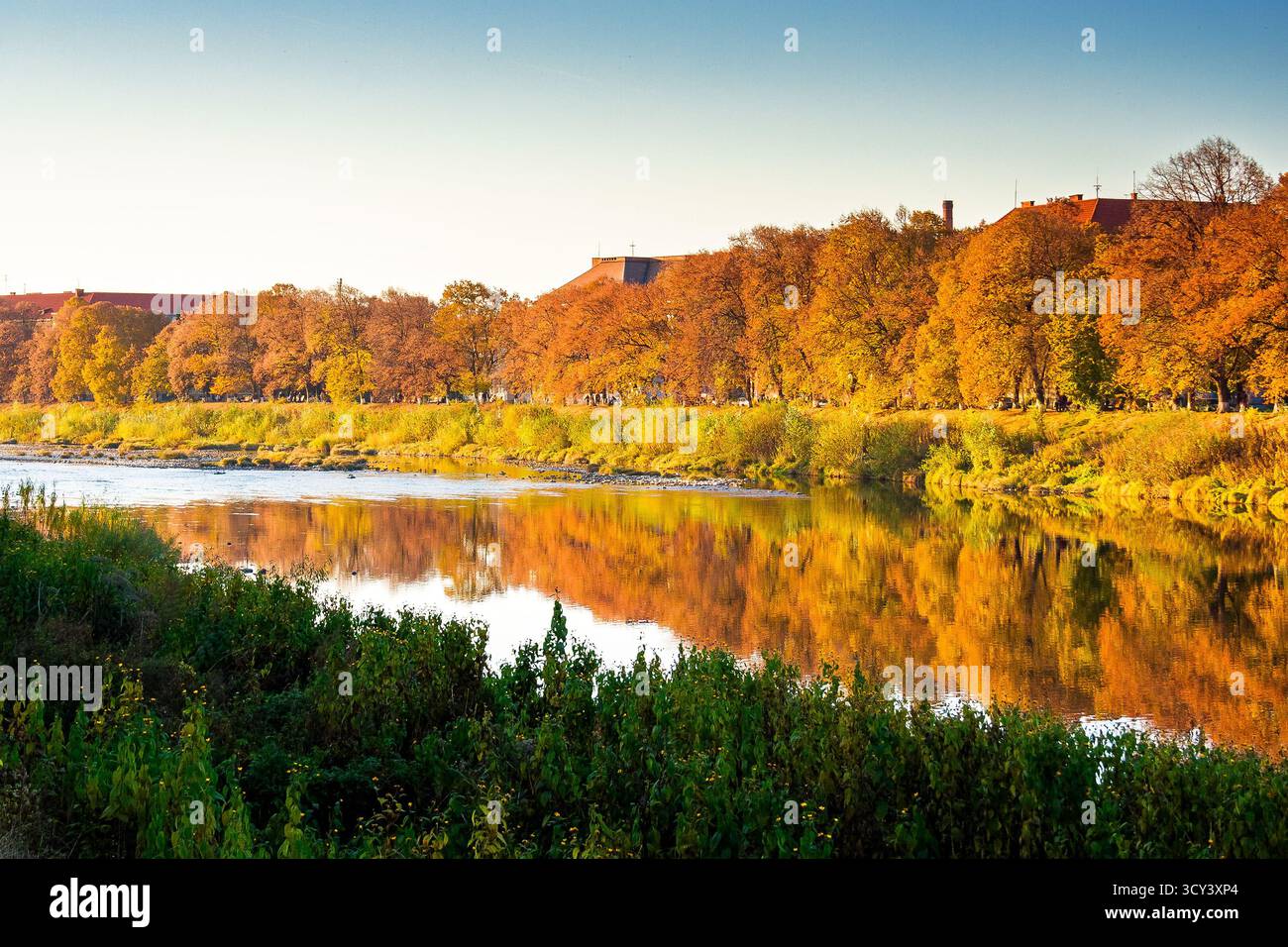 uzhhorod, ukraine - 31 oct, 2010: embankment of the river Uzh in autumn. beautiful view of old city with colorful foliage on trees in evening light. s Stock Photo