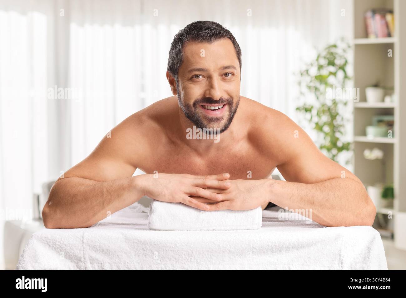 Man laying on a massage bed and smiling Stock Photo