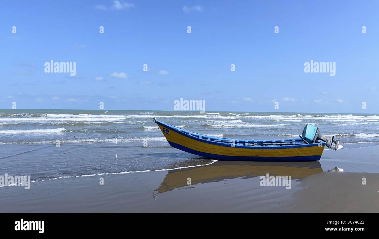 boat on sandy Caspian Sea beach under blue sky in Iran - Smartphone Captured Stock Image