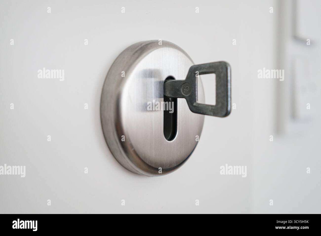 Close-up shot of a metal key inserted in door lock Stock Photo