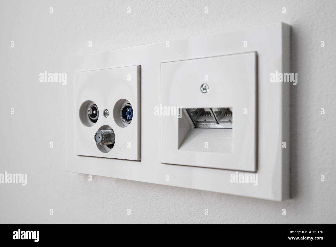 Cable Internet and phone socket installed on a wall Stock Photo
