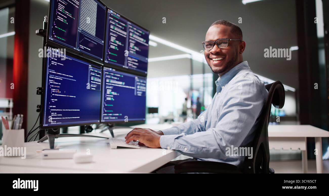 Happy African American Web Developer Coding At Office Desk Screen Stock Photo
