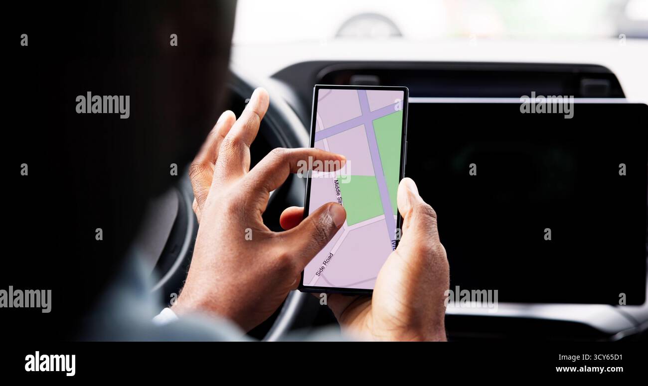 Auto Navigator: Young African American Man Using Smartphone GPS Mapping Stock Photo