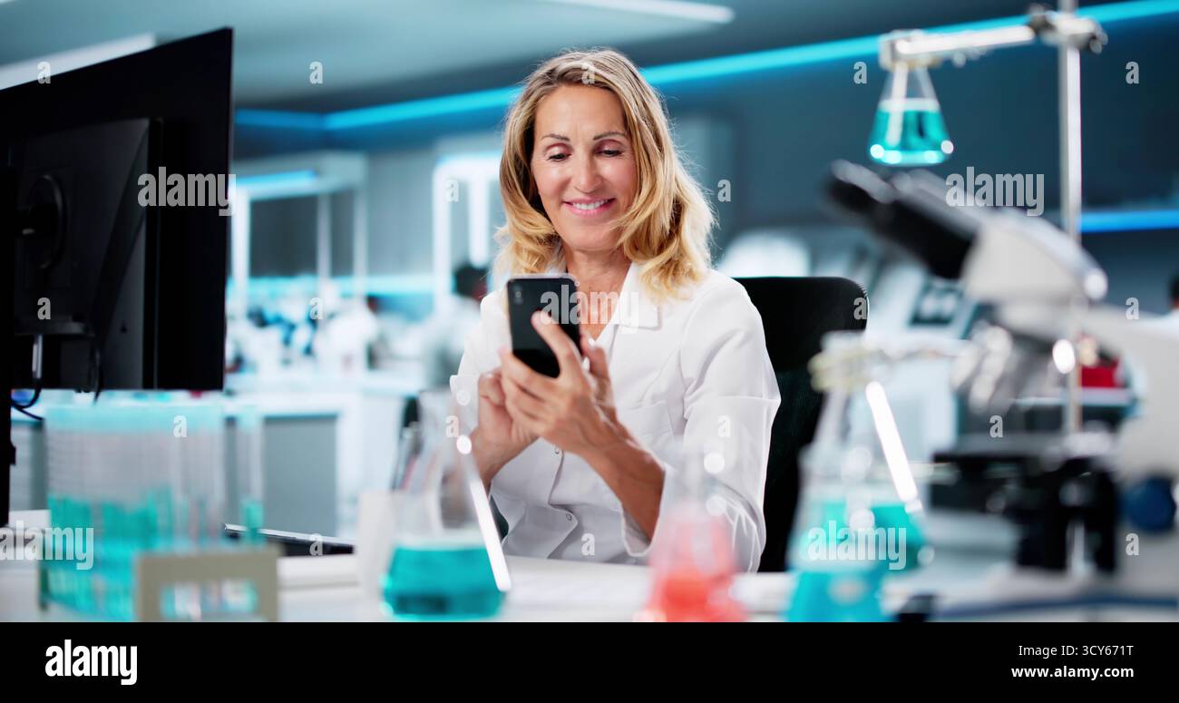 Woman Looking At Cell Phone, Texting, Viewing Document Stock Photo