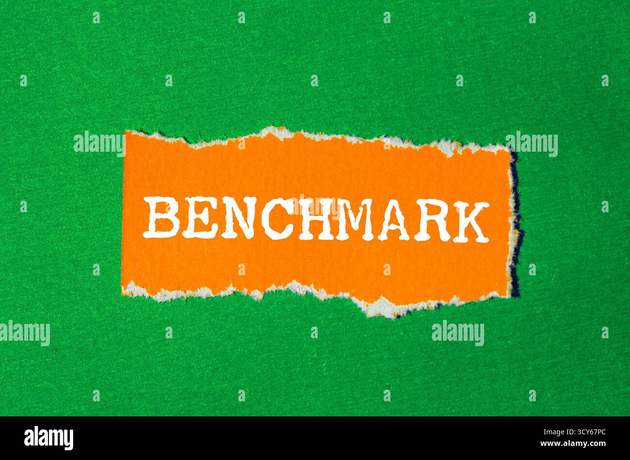 Benchmark message written on ripped torn paper background. Conceptual ...