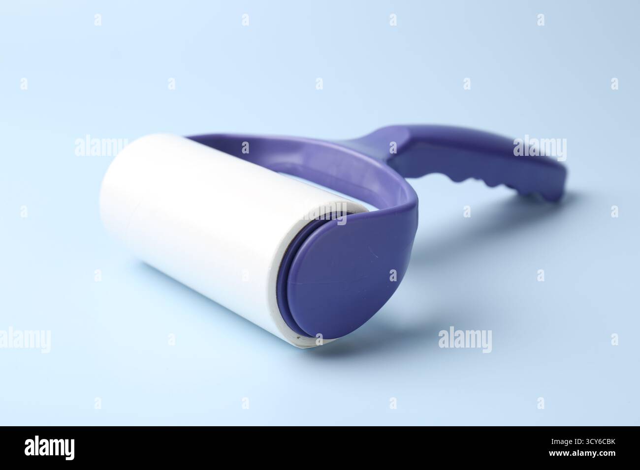 One lint roller on light blue background, closeup Stock Photo