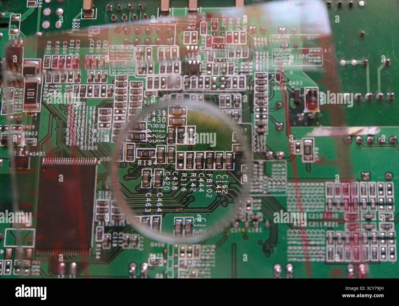 Surface mount components on electronic circuit under the magnifying glass. Stock Photo