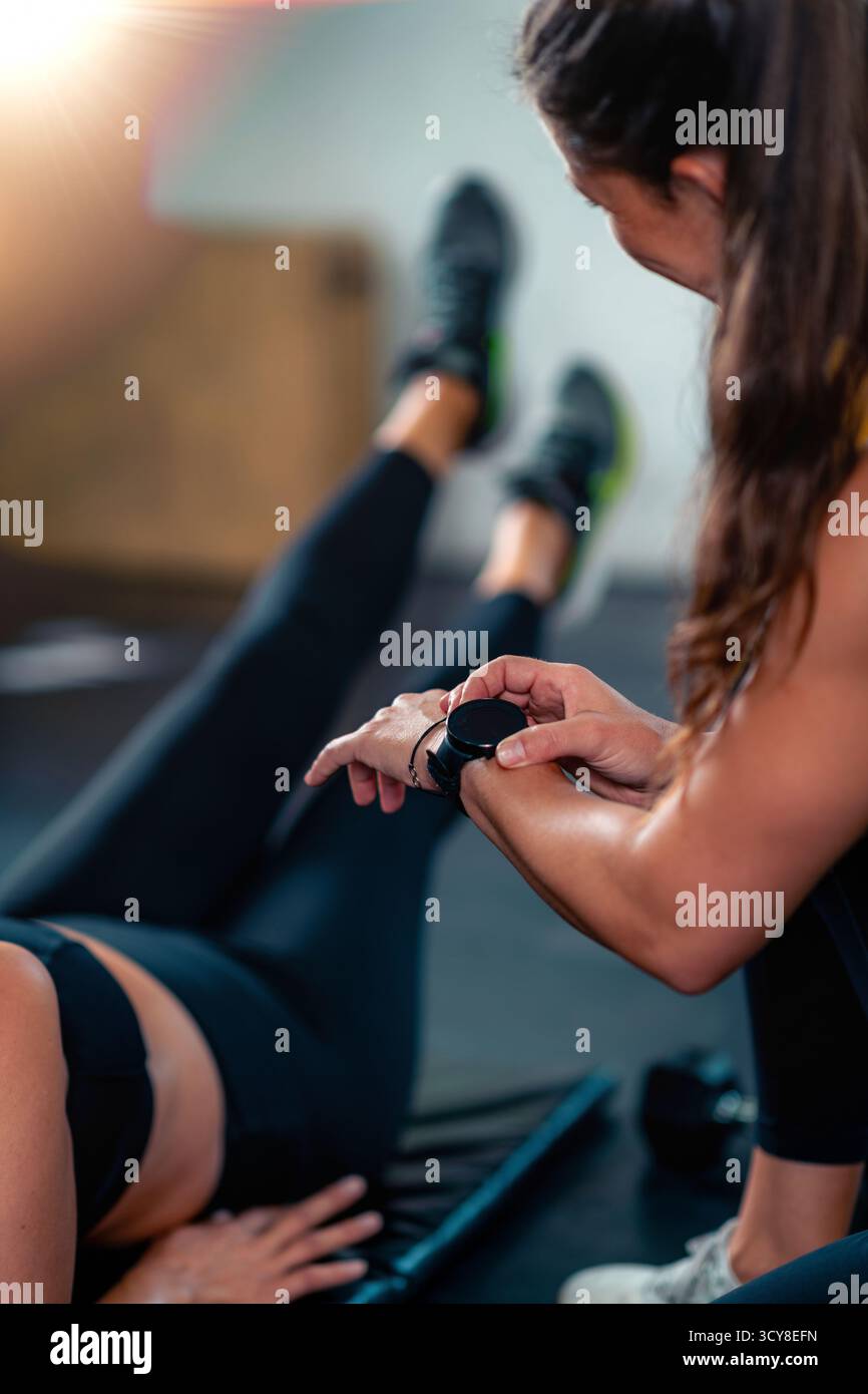 Personal fitness trainer coaching a woman in the gym. Stock Photo