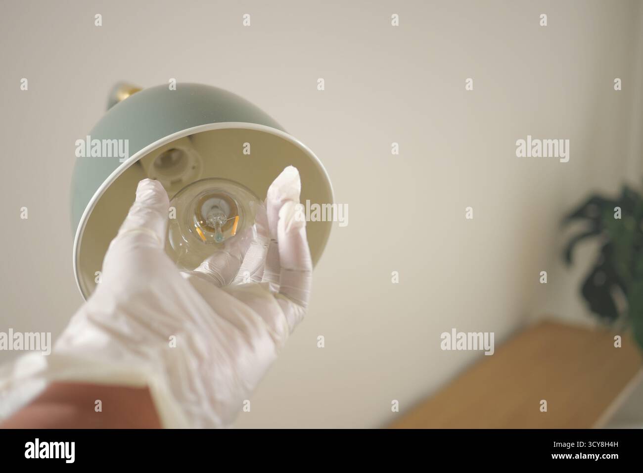 Replacing a light bulb in a modern lamp Stock Photo