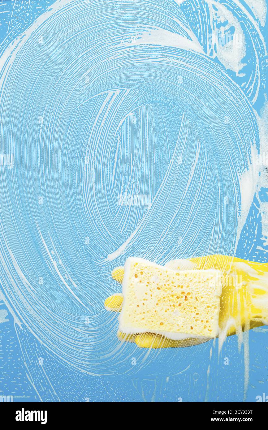 Man with sponge cleaning window on blue background Stock Photo