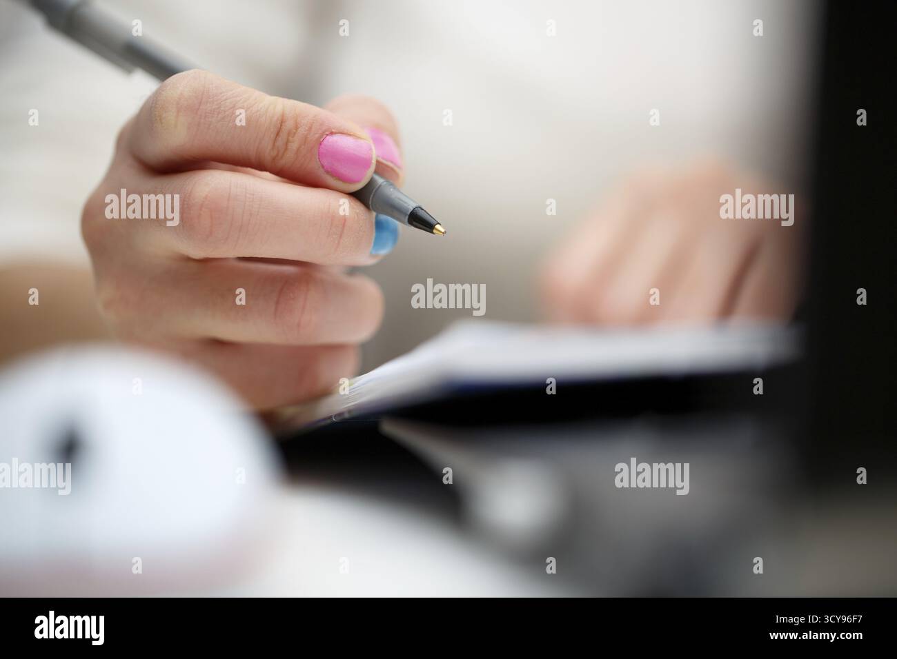 Female hands with pen writing on notebook Stock Photo