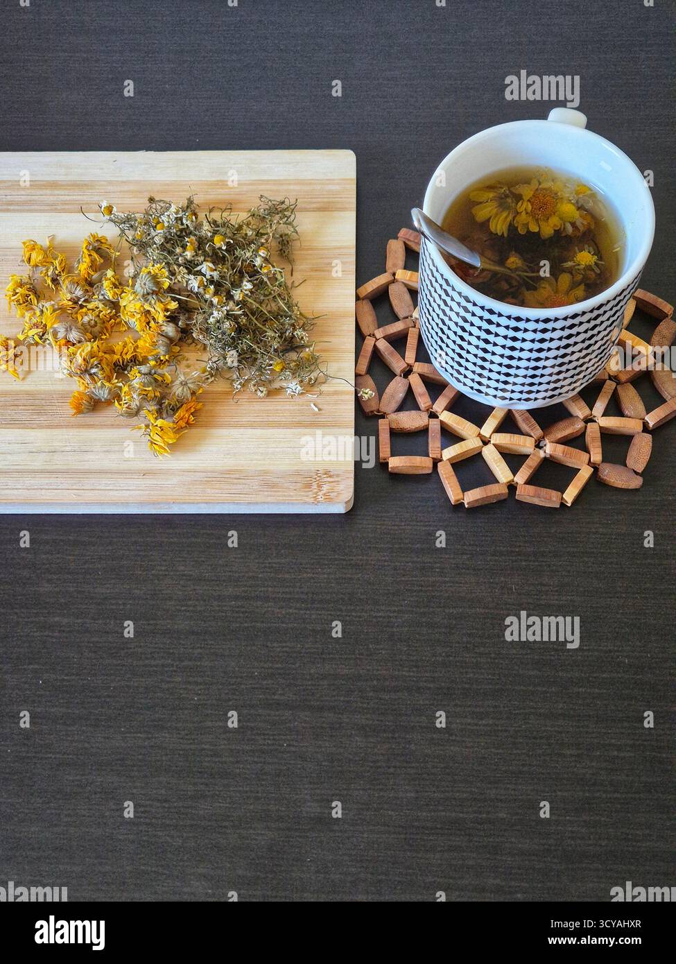 herbal tea with calendula and chamomile in a cup. on the board dried herbs calendula and chamomile - Smartphone Captured Stock Image