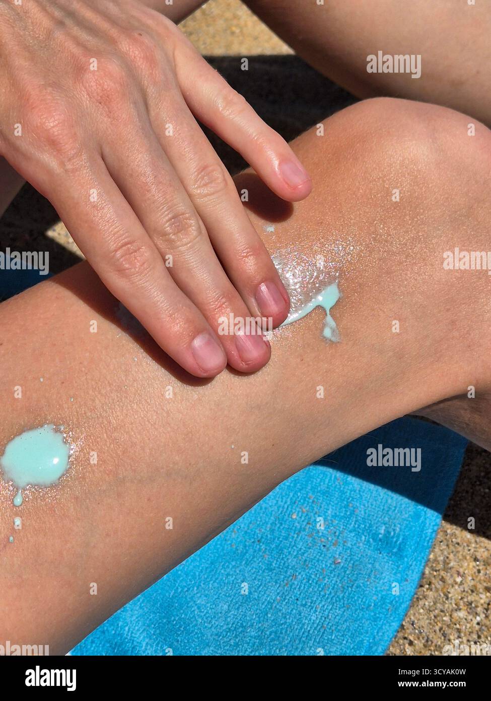 Napiying applying sunscreen to the body. applying spf to the legs Stock Photo ...