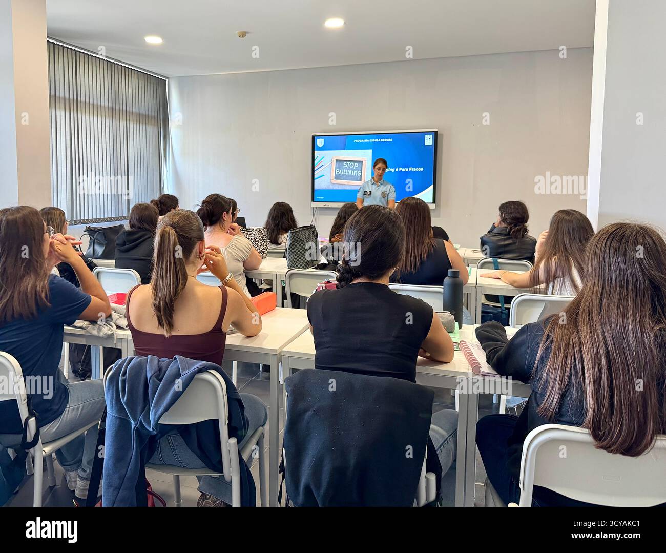 Police-led anti-bullying education session in a Portuguese school classroom with students learning about building a peaceful future. - Smartphone Captured Stock Image
