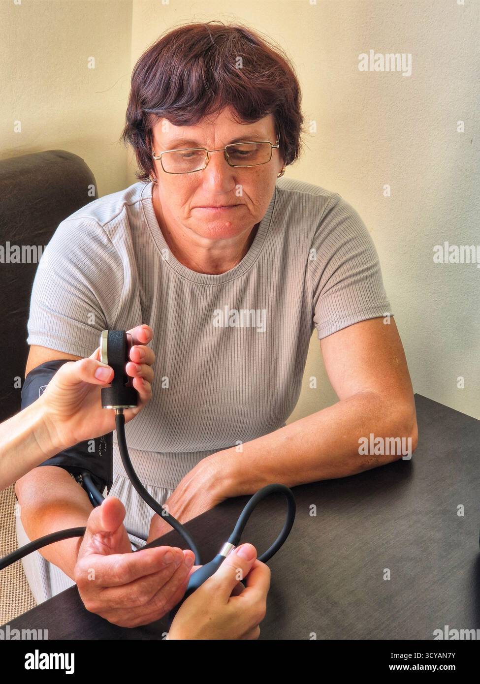 woman having her blood pressure measured. healthcare. hypertension. 60 year old woman with a blood pressure measuring device - Smartphone Captured Stock Image