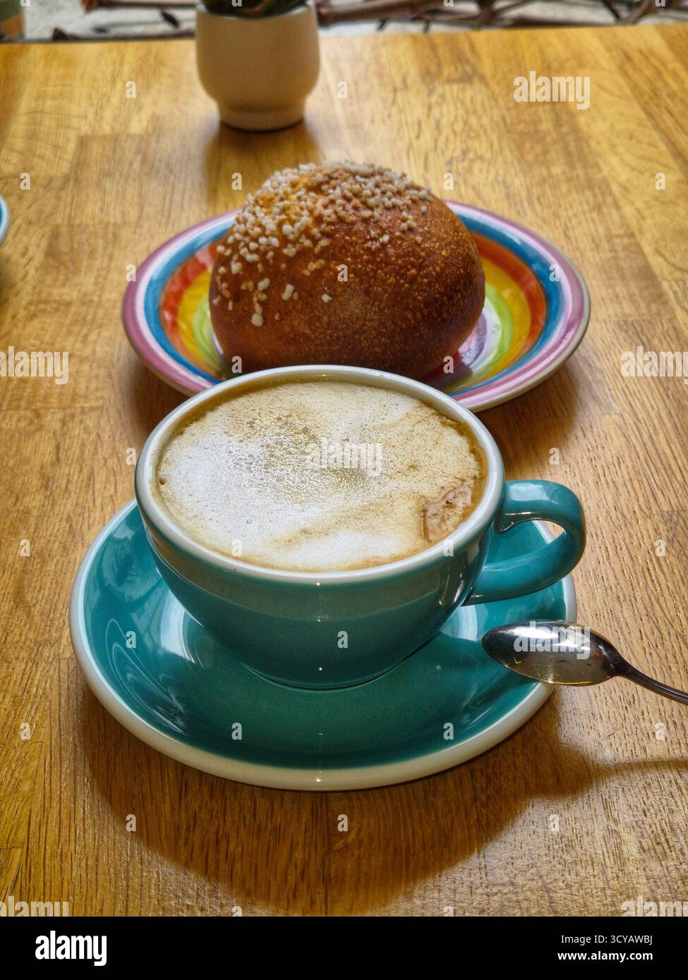 Turquoise colored cup of coffee with foam and pastries. - Smartphone Captured Stock Image