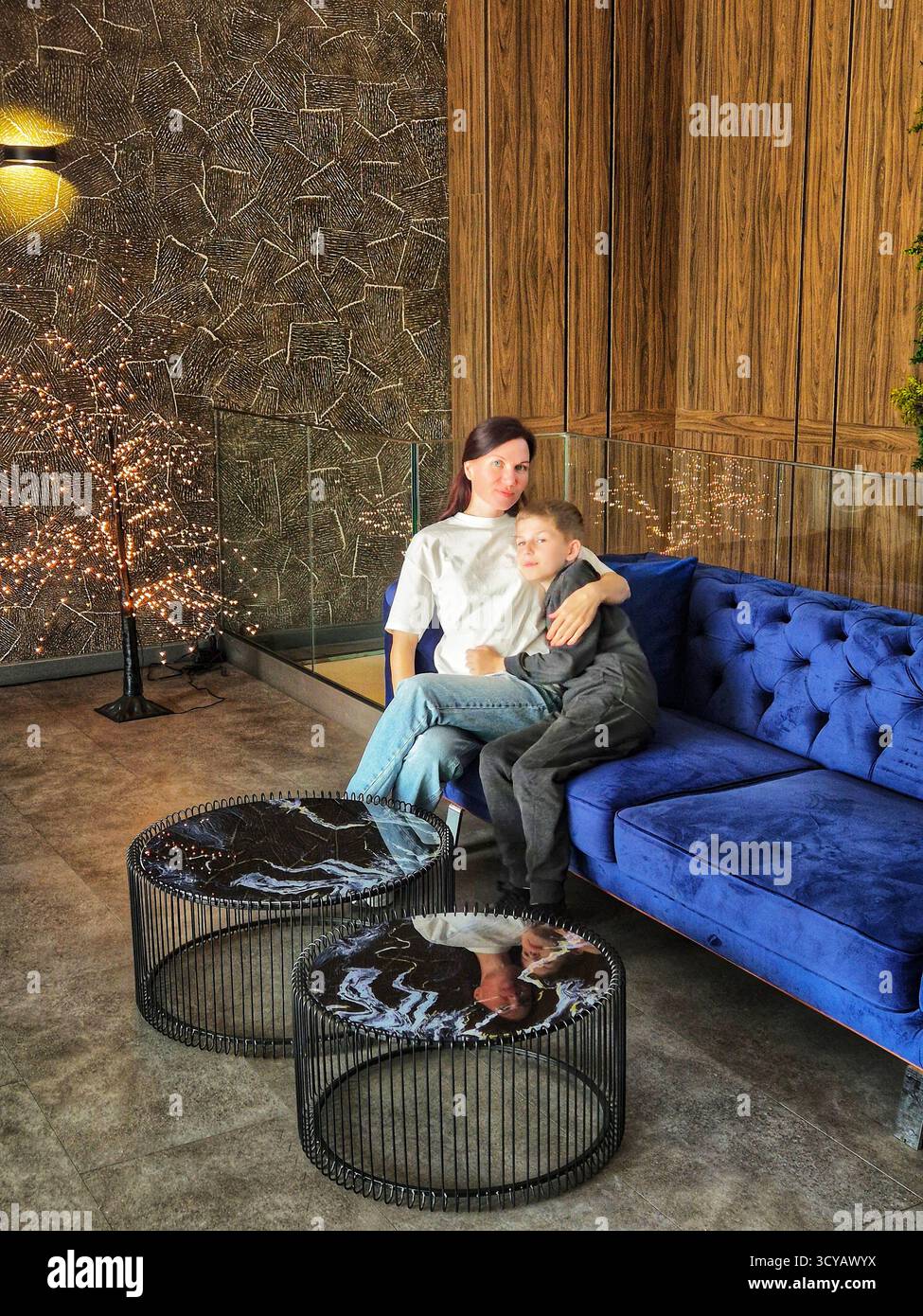 mom and son on a beautiful blue sofa. mom and son time. bright blue sofa - Smartphone Captured Stock Image