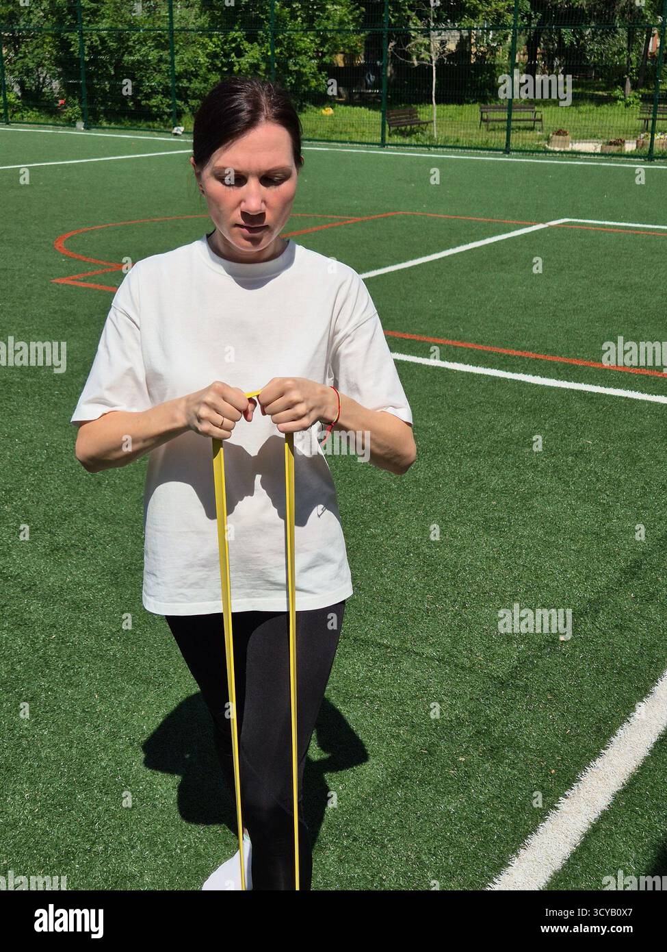Young woman doing fitness or yoga outdoors in the park. - Smartphone Captured Stock Image