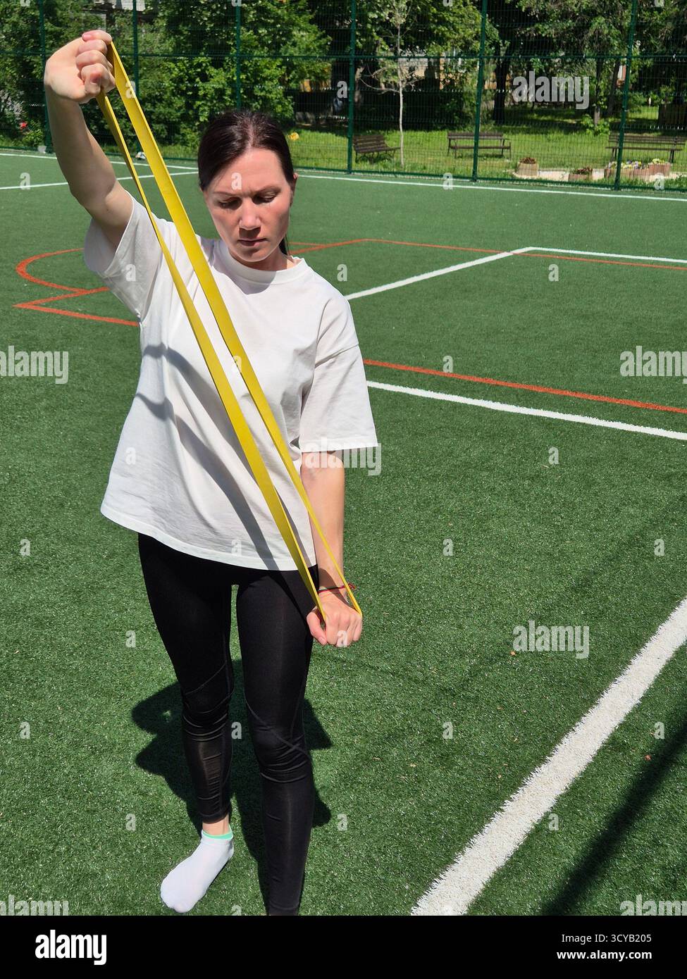Young woman doing fitness or yoga outdoors in the park. - Smartphone Captured Stock Image