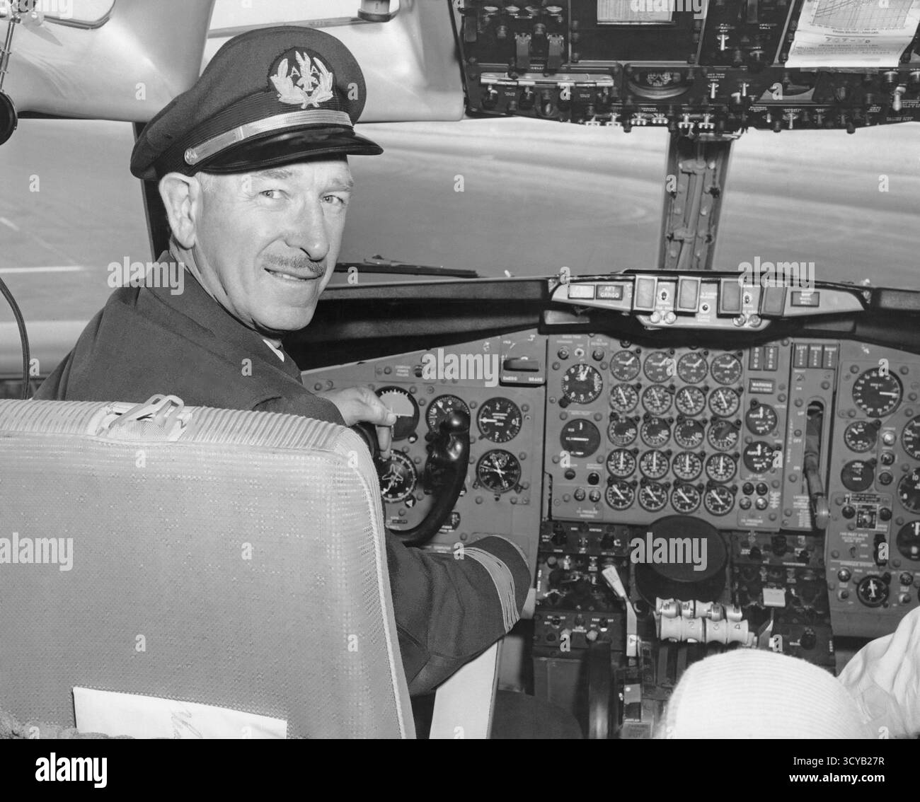 Middle aged airline pilot sitting at the controls Stock Photo