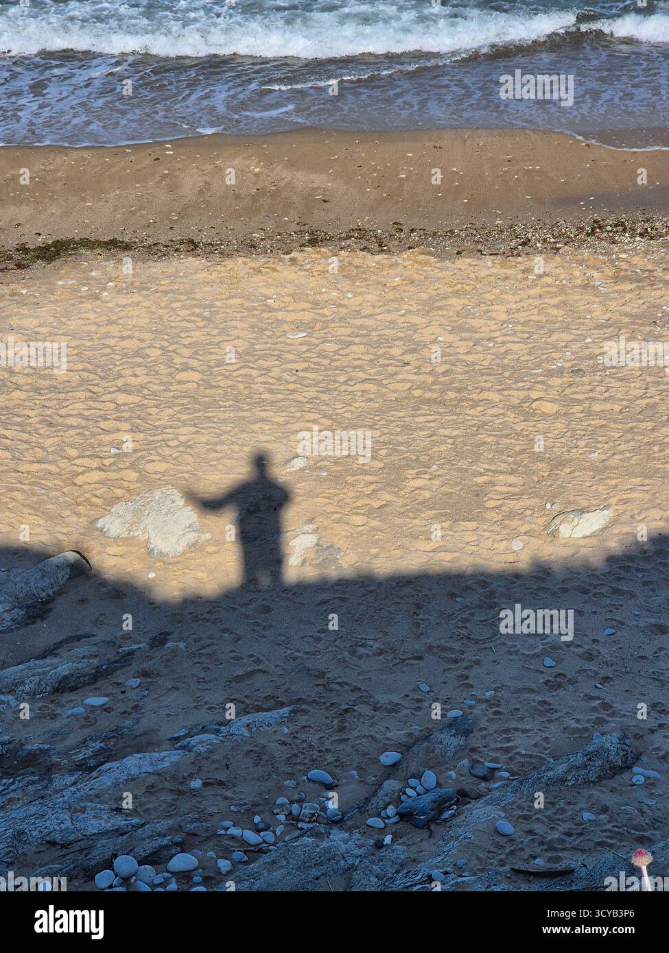 Shadow of a person on a sandy beach by the sea. - Smartphone Captured Stock Image