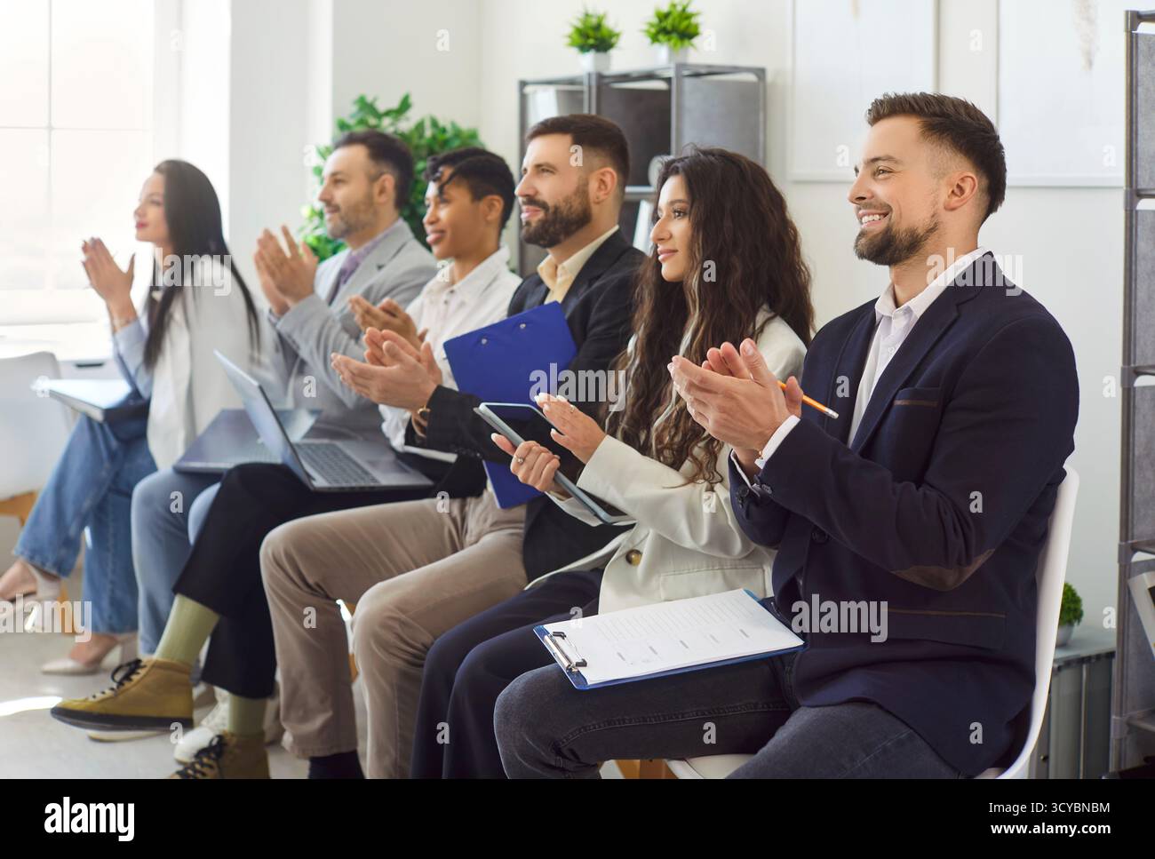 Group Applausing Images Happy diverse group applauding sitting on chairs in modern office room ...