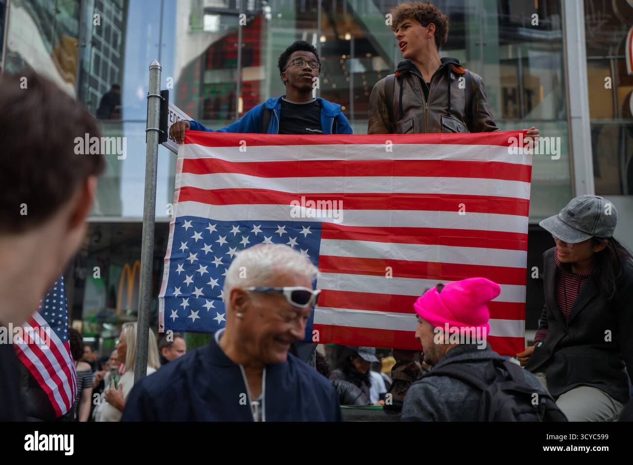 Protesters hold an upside-down US flag during a "No Kings" protest ...