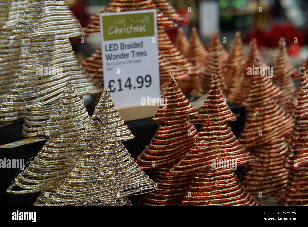 LED braided Christmas trees in red and gold on festive display with ...