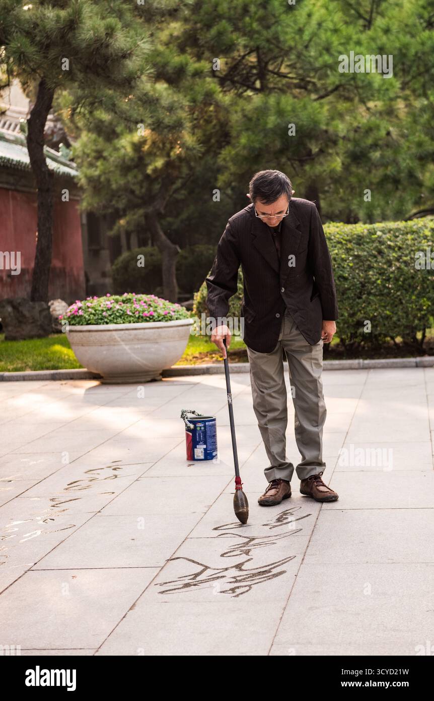 Beijing, China - October 5, 2018: Ground calligraphy, painting with water, on the ground in China is a popular and ancient practice. Stock Photo