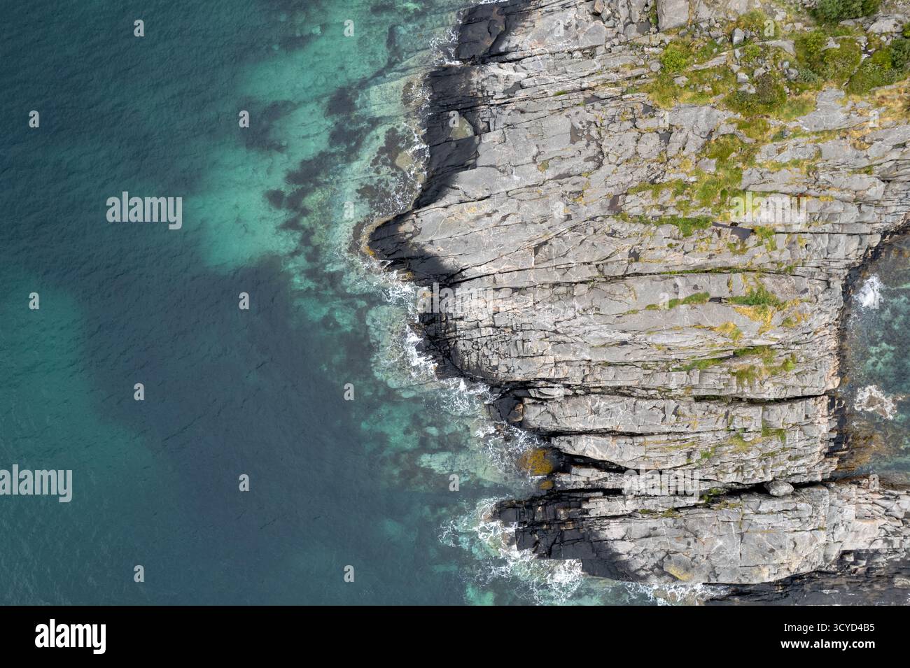 Turquoise water crashing on rocky coastline. Rocky seascape. Drone aerial landscape Lofoten islands Stock Photo