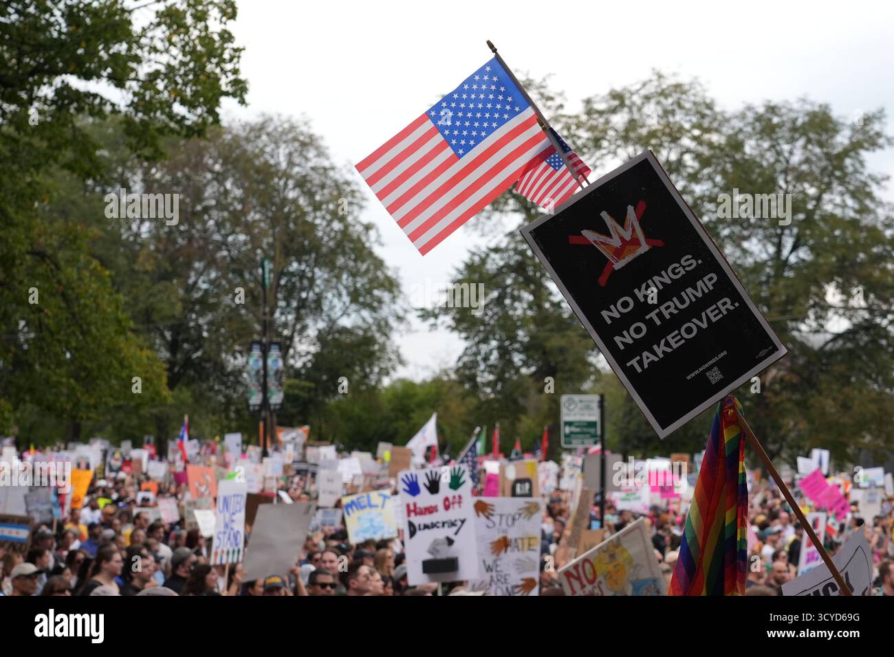 People hold signs and flags during a