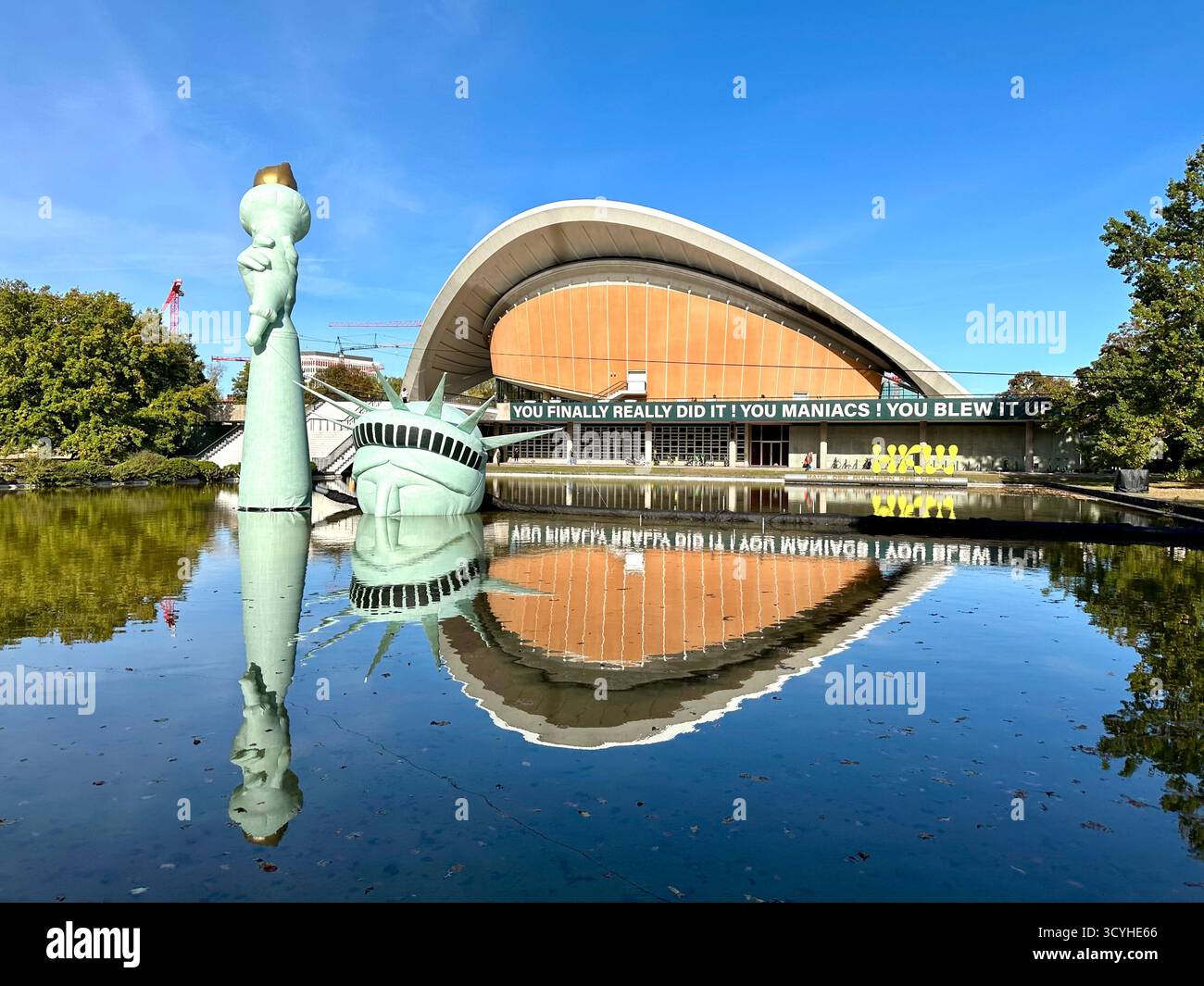 An inflatable Statue of Liberty floats in a pool outside the Haus der Kulturen der Welt, installation with the title status of liberty - Smartphone Captured Stock Image