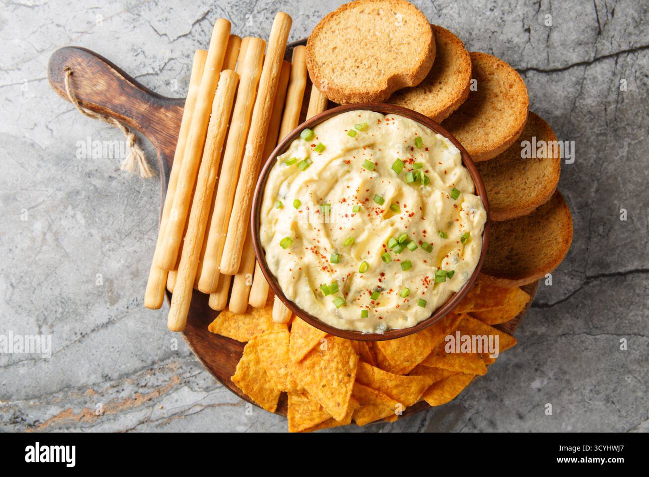 Deviled Egg Dip festive buffet appetizer with chips, breadsticks and biscuit close-up in a plate on the table. Horizontal top view from above Stock Photo